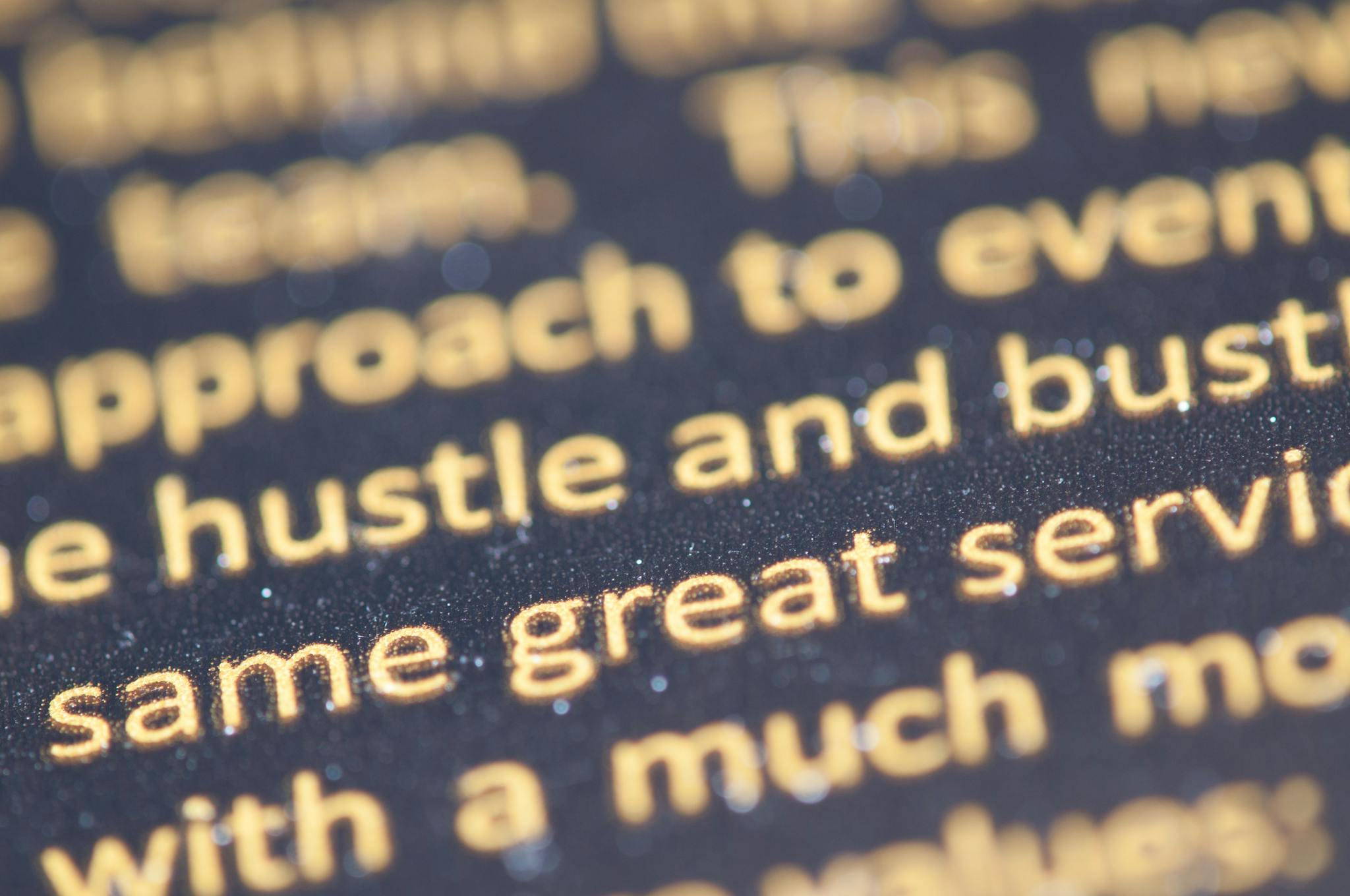 Macro shot of golden text highlighting typography on a dark background.