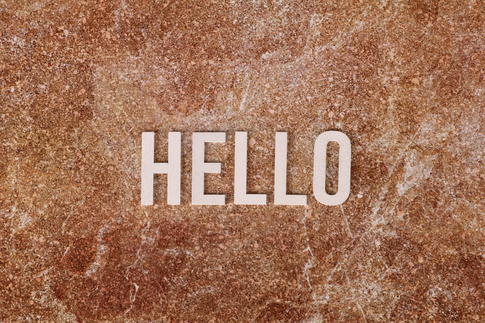 Simple text saying 'HELLO' on a textured stone background, suitable for greetings.